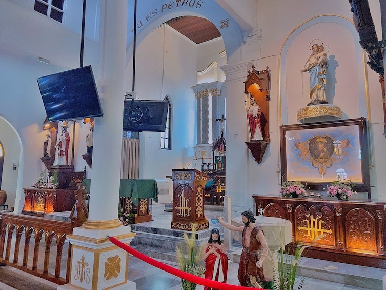 An interior of a church with statues, altars, and a red carpet. 2