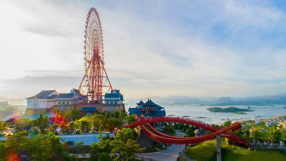 A roller coaster, a Ferris wheel, traditional buildings, and a body of water. 2