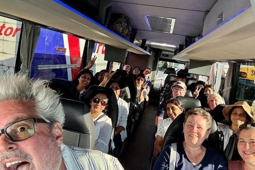 Un groupe de personnes se trouve dans un autobus dont les fenêtres sont décorées de rayures bleues et rouges. 3