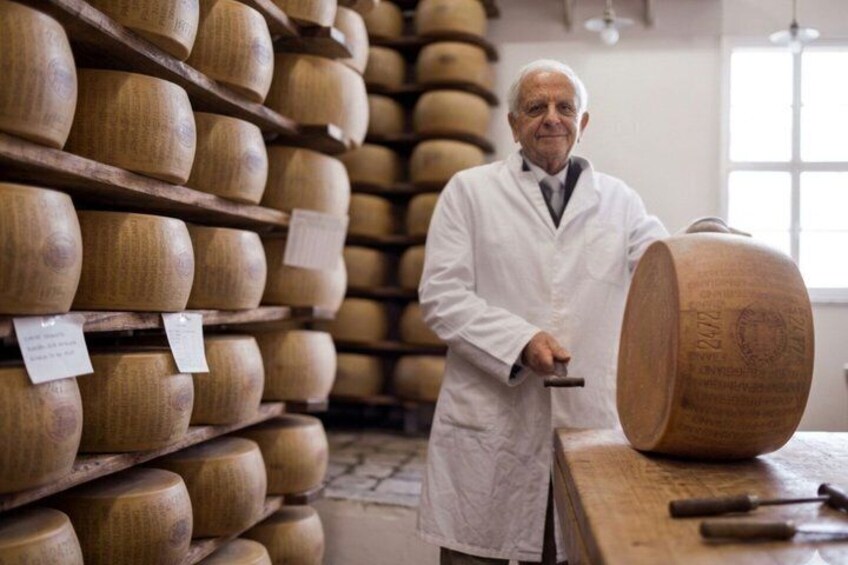 Une personne en blouse de laboratoire inspecte des barils en bois dans une salle de stockage. 4