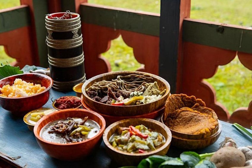 Variedad de platos tradicionales sobre una mesa de madera al aire libre. 5