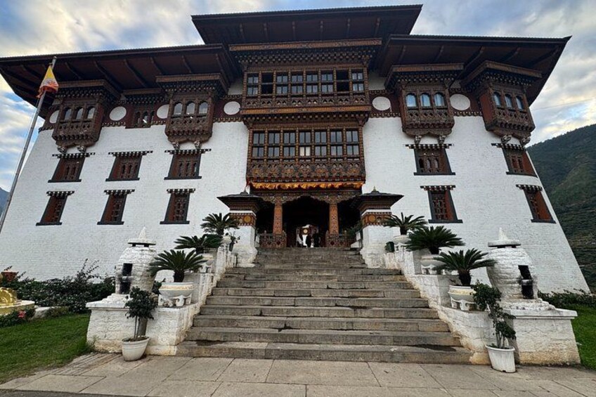 Un edificio tradicional con balcones de madera ornamentados y una escalera que conduce a la entrada. 2