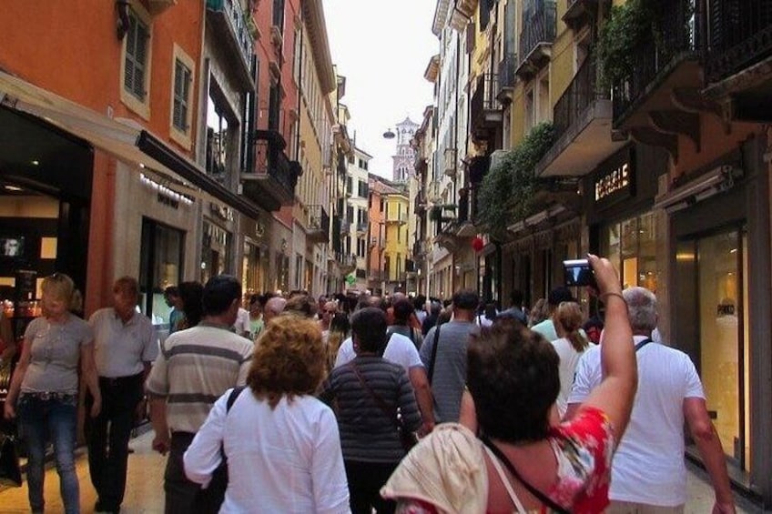 A crowded street with people walking and taking photos. 3