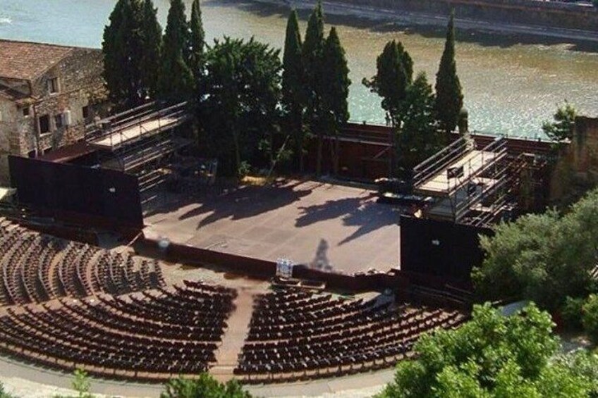 An outdoor amphitheater with tiered seating and a stage. 4