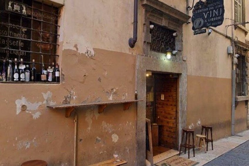 A building with peeling paint and a sign that reads 'VINI'. 2