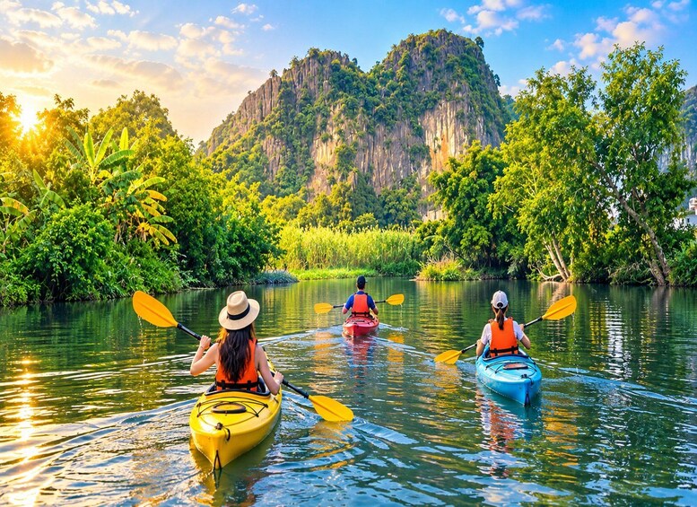 Three kayakers on a calm river surrounded by lush greenery and a prominent mountain in the background. 2