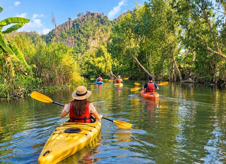 People kayaking on a river surrounded by lush greenery and hills. 5