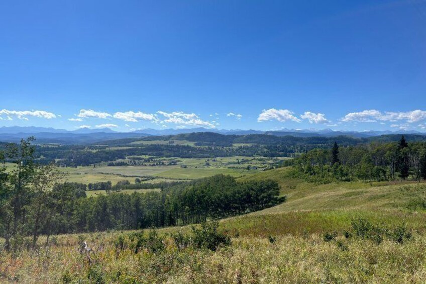 A mountainous landscape with a clear sky, rolling hills, and distant mountains. 4
