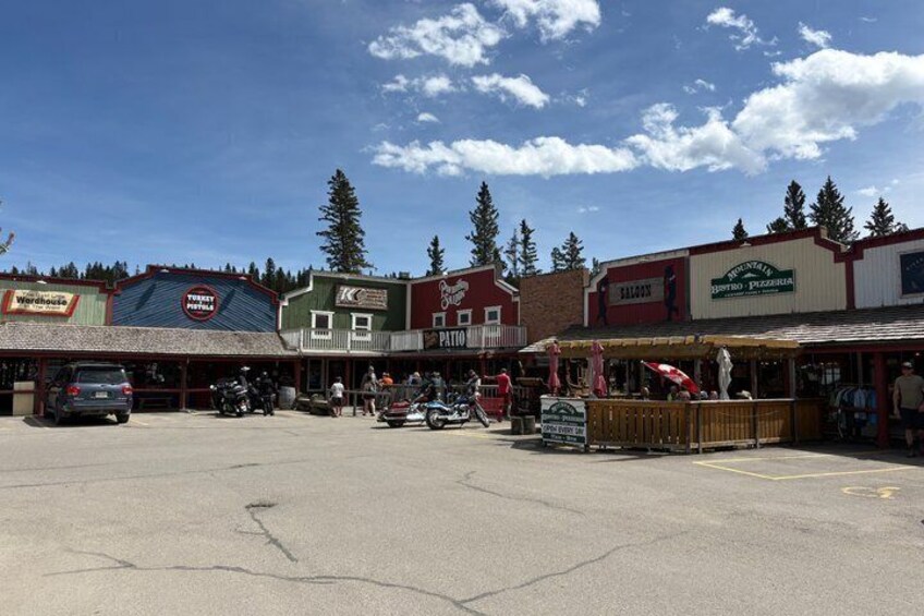 A town square with shops, a covered seating area, and a parking lot. 2