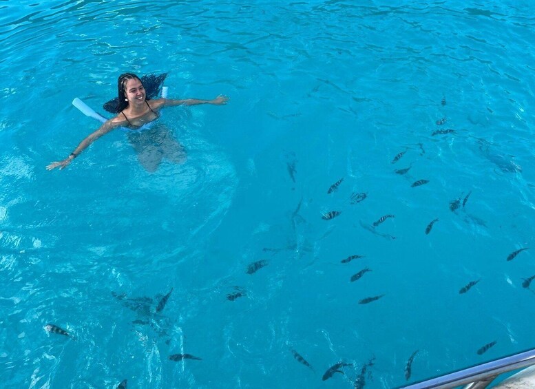 A person swimming in a pool with fish. 1