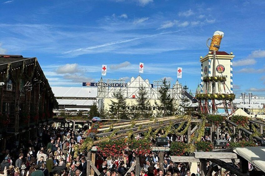 Ein belebtes Freiluft-Event mit einem großen Gebäude, einem Glockenturm und Flaggen. 4