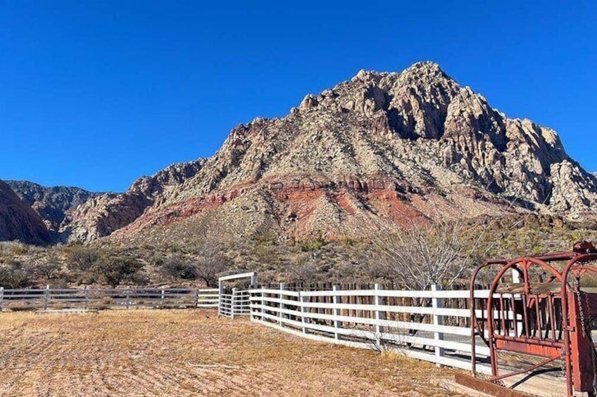 A mountainous landscape with a white fence and a red gate. 3