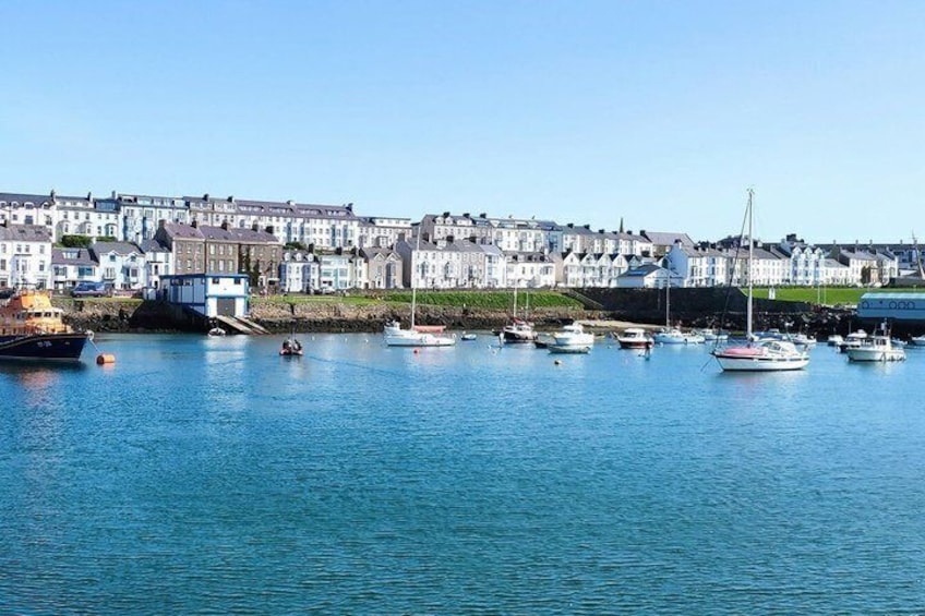 A harbor with boats, a row of houses, and a clear blue sky. 4