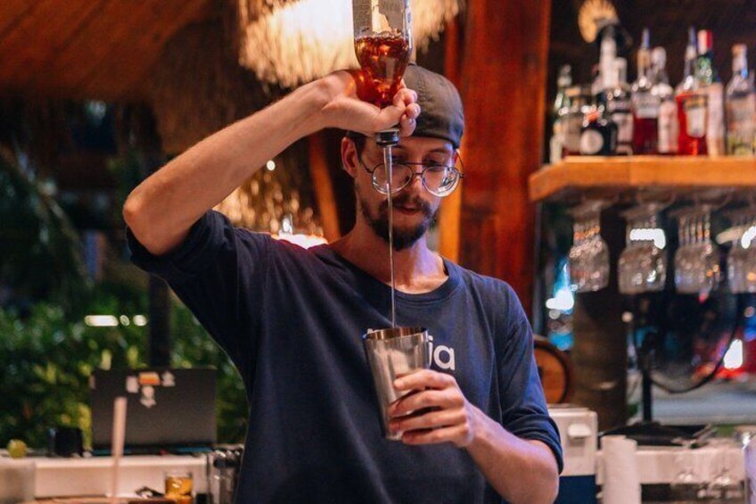 A person pouring a drink from a bottle into a glass. 3