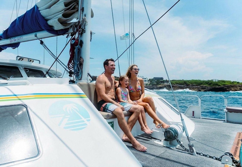 A family on a sailboat with a clear sky and ocean in the background. 4