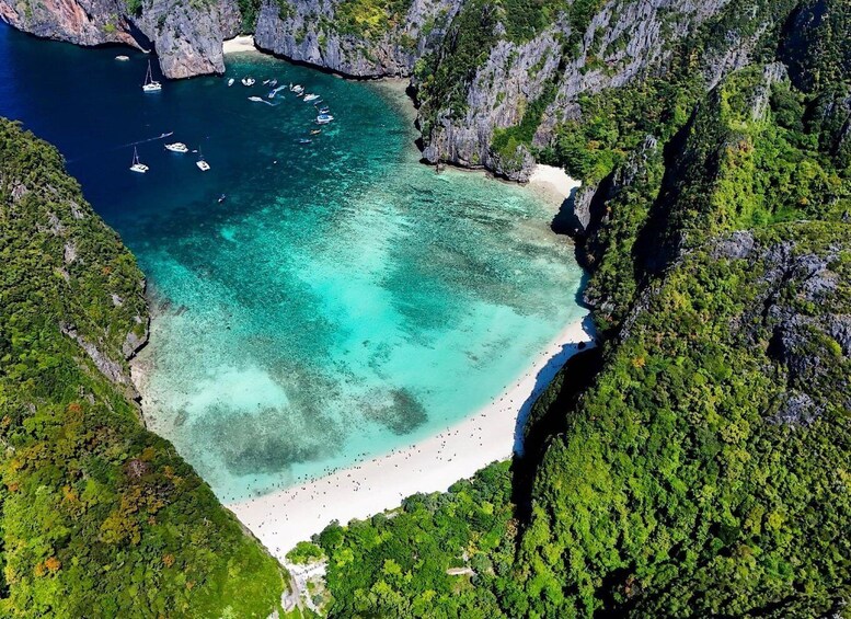 A coastal landscape with a beach, clear turquoise waters, and surrounding cliffs. 4
