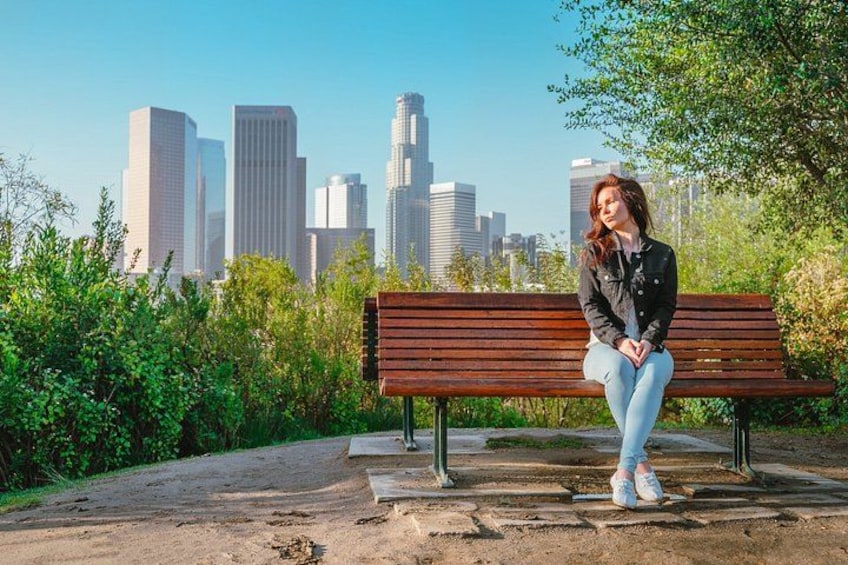 Une personne assise sur un banc, avec la silhouette d’une ville en arrière-plan. 4