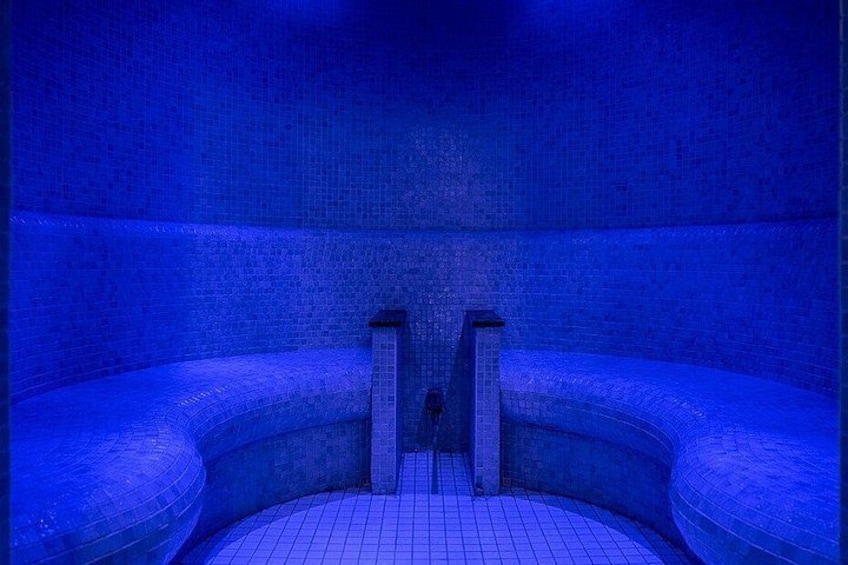 Een kamer in blauw licht met een gebogen bank en een ladder. 2