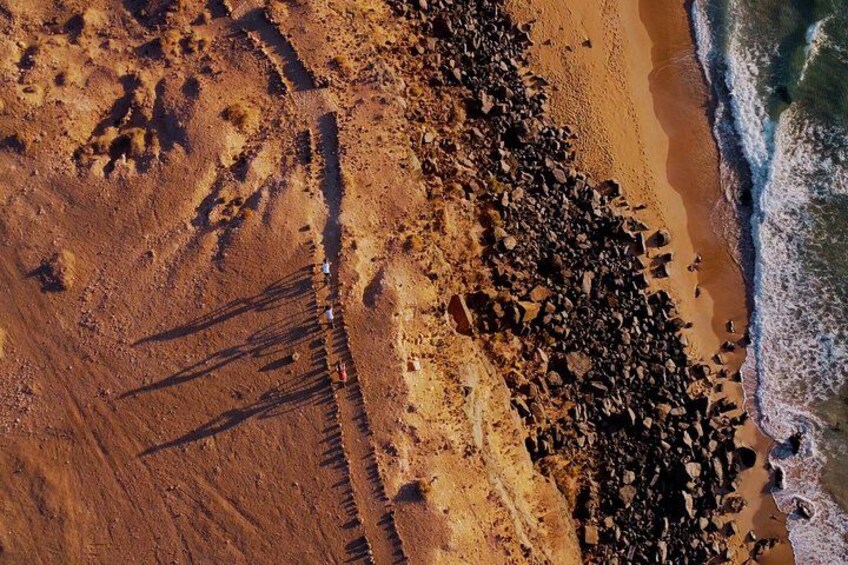 Una playa con costa rocosa y olas rompiendo sobre la arena. 5