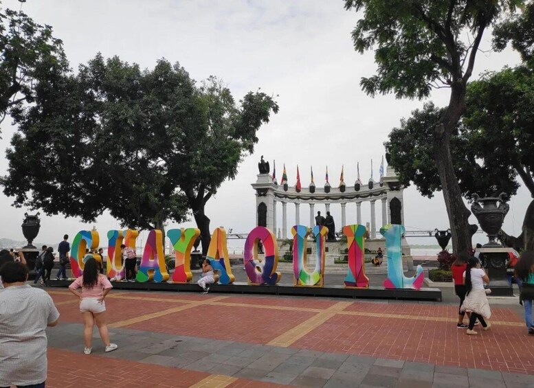 A plaza with colorful letters spelling 'CHAYACUIT' and a statue in the background. 3