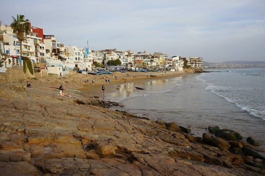 A rocky beach with buildings in the background. 4