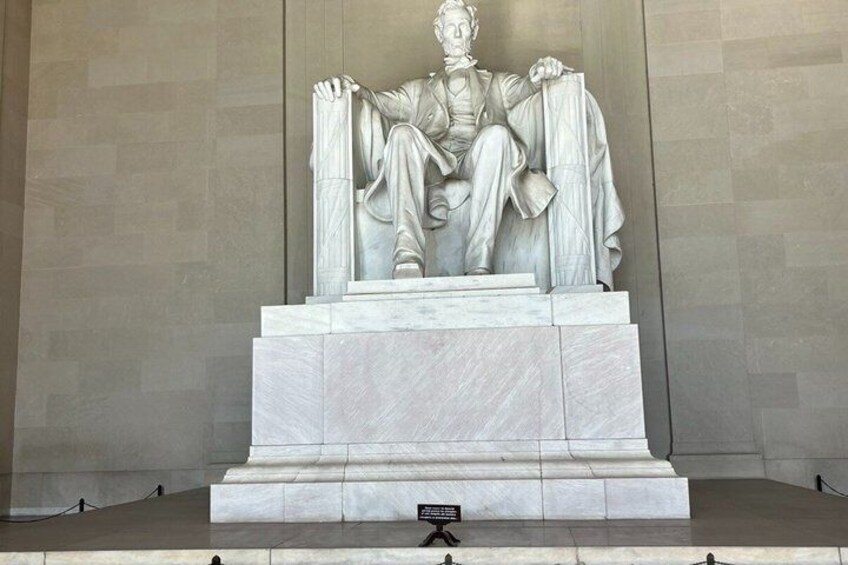 A marble statue of a seated figure on a pedestal. 5