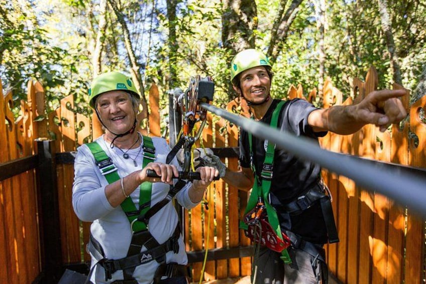 To personer i sikkerhedsudstyr og hjelme gør sig klar til at zipline. 4