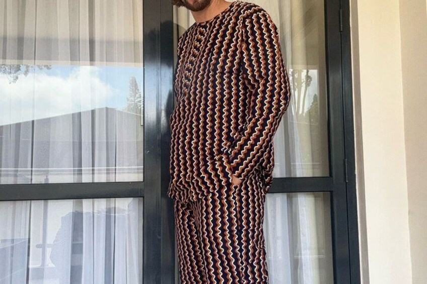 En person står foran et vindue iført et mønstret outfit. 3