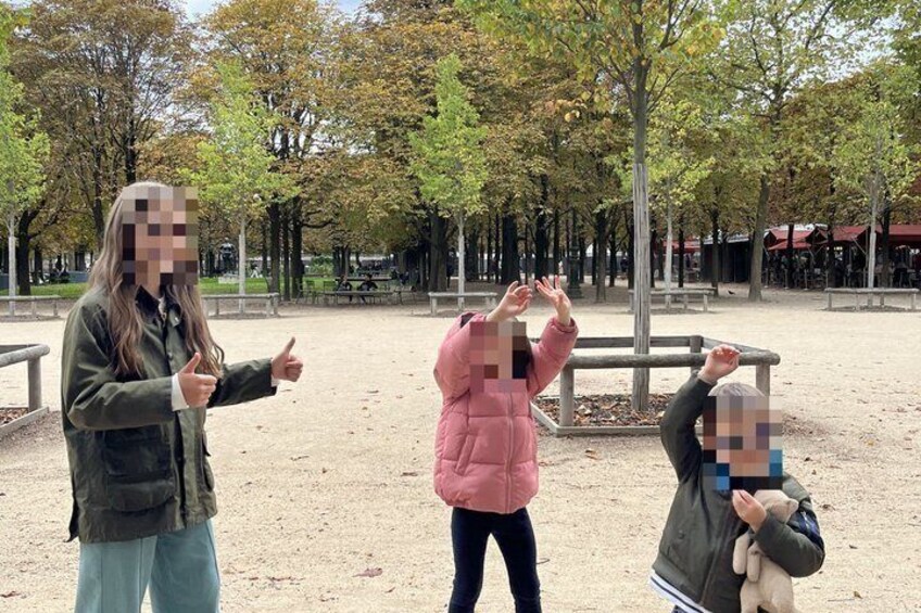 Three people in a park with trees and a dirt ground. 4