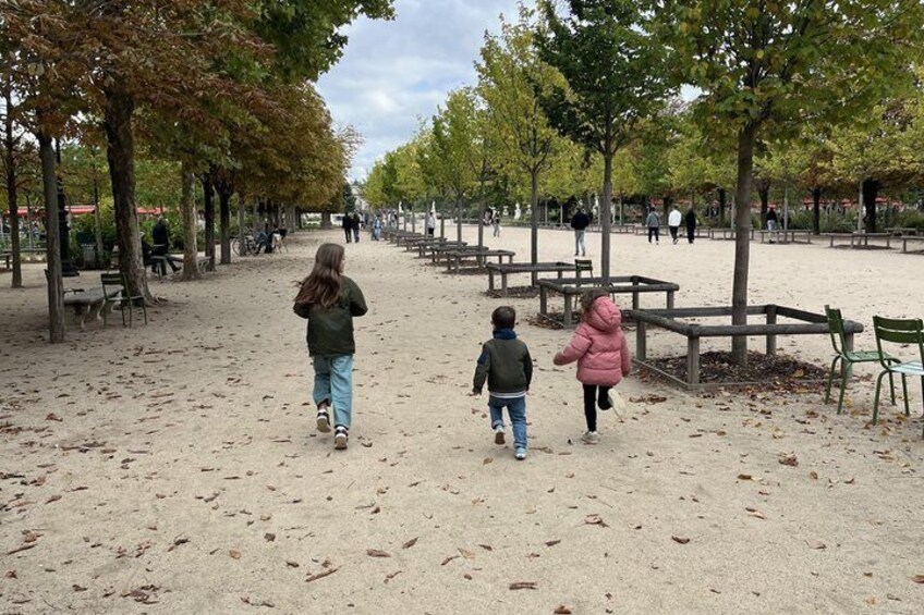 A sandy park with trees and benches. 2