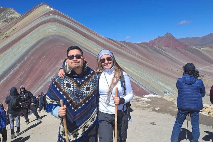 A group of people hiking in a mountainous area with colorful rock formations. 2