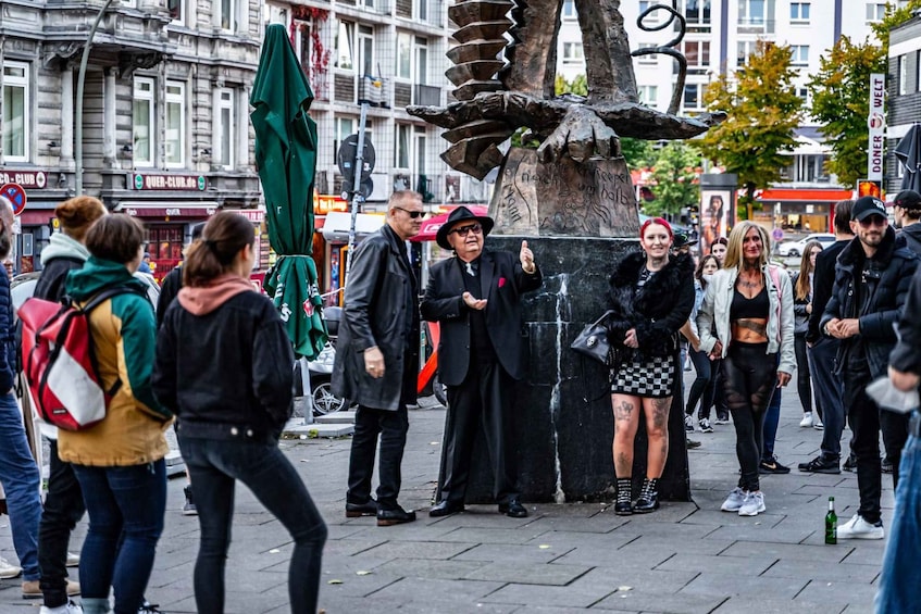 A busy urban street with pedestrians, a public fountain, and buildings with signage. 2