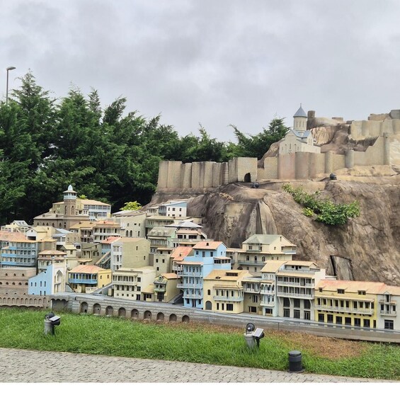 A model cityscape with colorful buildings and a large rock formation in the background. 4