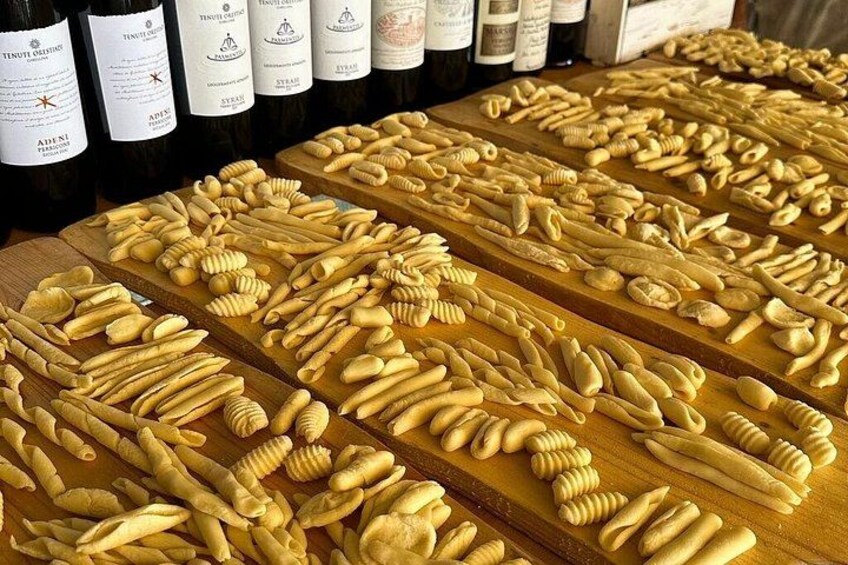 Forskellige pastatyper og vinflasker på træfade. 3