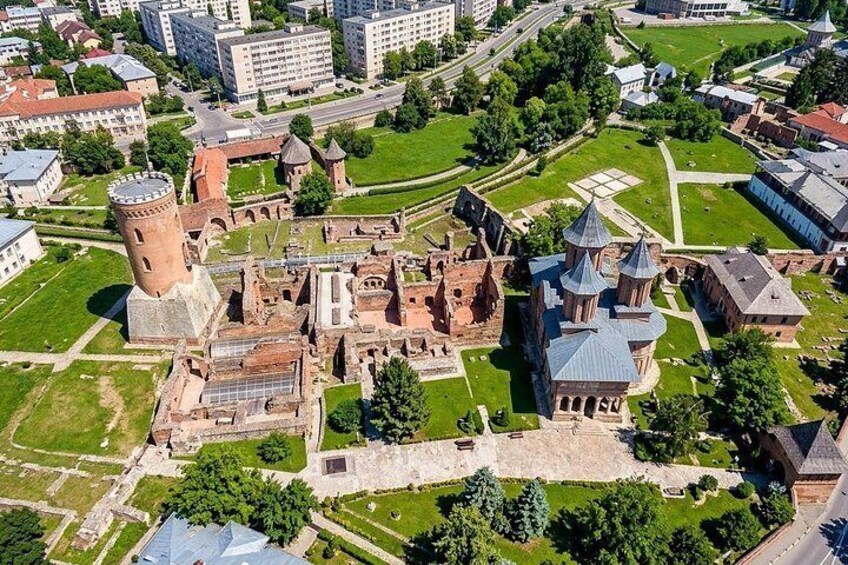 An aerial view of a historic complex with ruins, a tower, and a church with multiple domes. 4