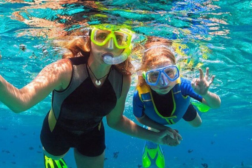 Two people snorkeling underwater. 1