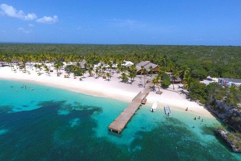 A beach with a pier extending into turquoise waters, surrounded by palm trees and a clear sky. 3