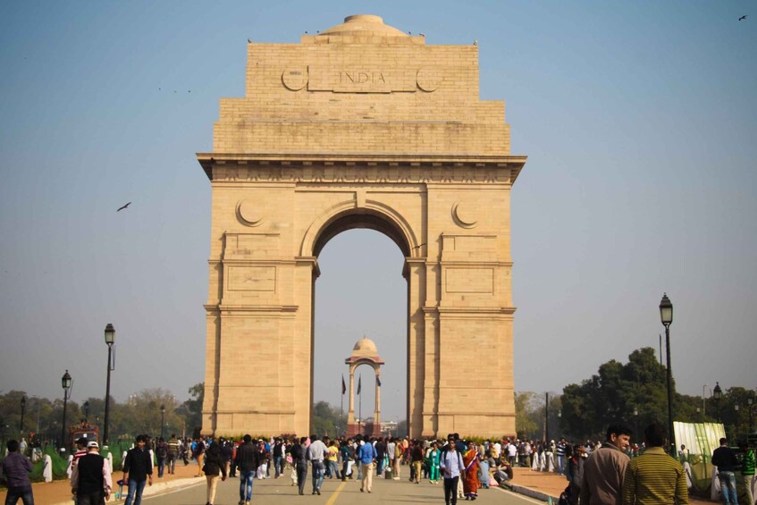 The India Gate with a crowd of people in the foreground and a clear sky. 3