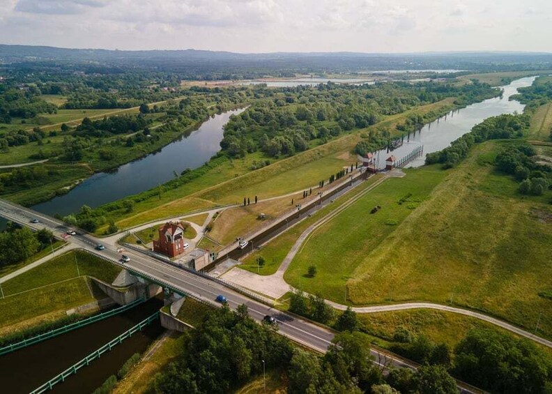 A river with a bridge, a highway, and green fields. 5