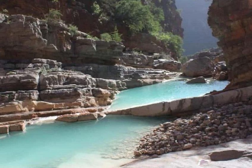 A turquoise river flowing through a rocky canyon with a rocky shoreline. 2