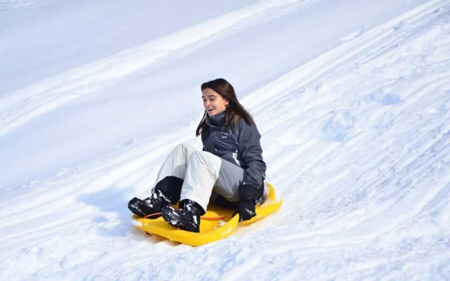 A person sledding down a snowy slope. 1