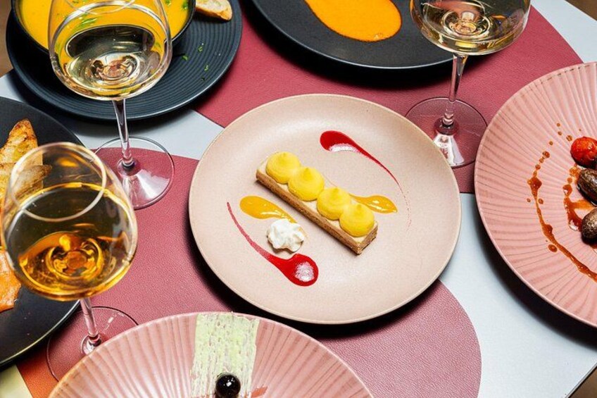 Une table avec des assiettes de nourriture et des verres de vin. 5
