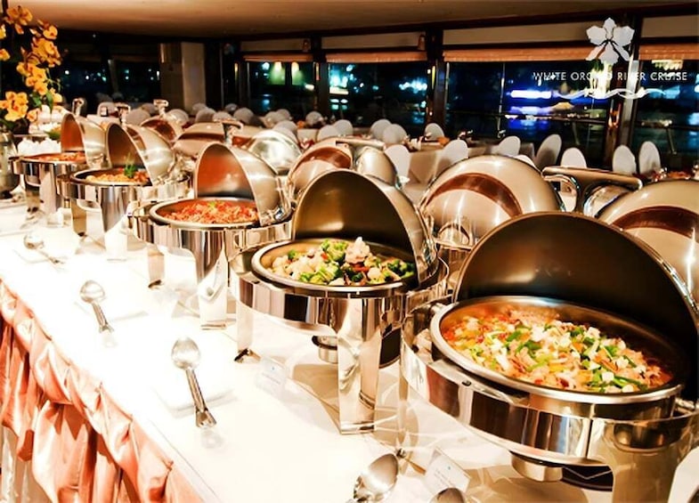 Un bufé con varias estaciones de comida, cada una con un recipiente cubierto y una cuchara. 5