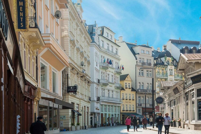 A cobblestone street lined with historic buildings, some with balconies and flags. 5