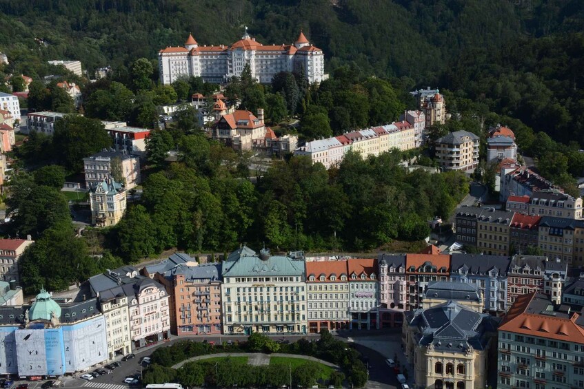 A historic town with a prominent castle on a hill, surrounded by lush greenery and traditional architecture. 3