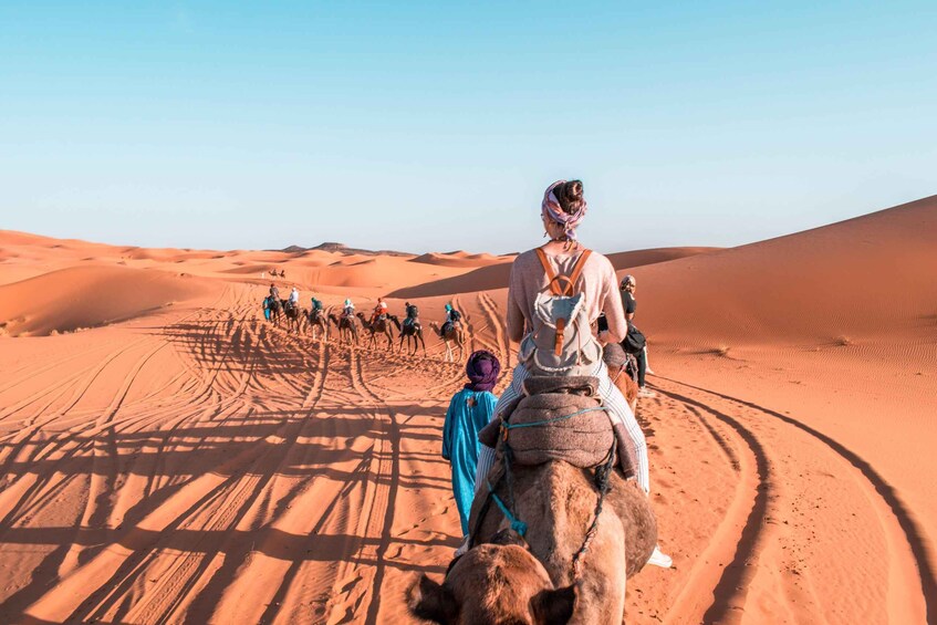 Una caravana de camellos atraviesa un desierto bajo un cielo despejado. 3