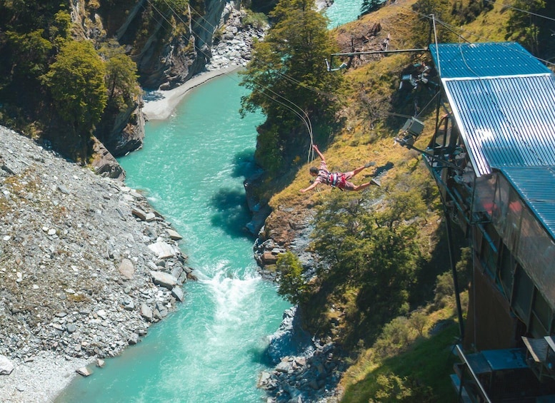 A person bungee jumping off a bridge over a turquoise river. 3