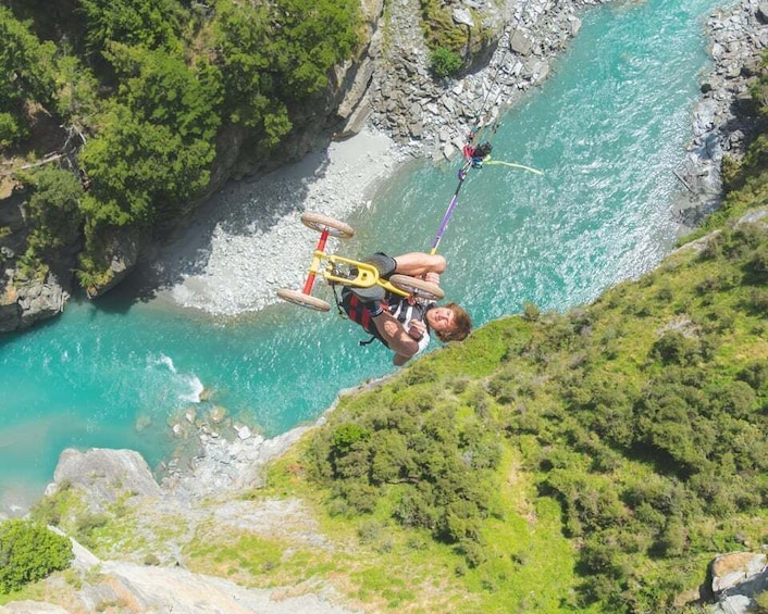 A person bungee jumping from a cliff over a turquoise river. 5