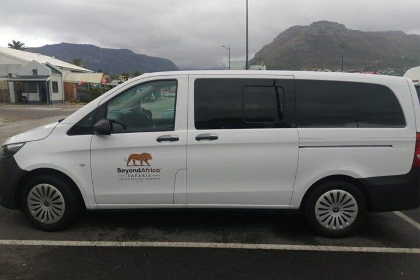 A white van with 'BeyondAfrica Safaris' branding parked on a road. 5