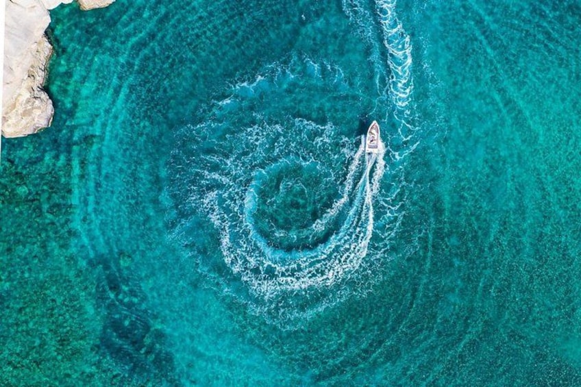 Una embarcación dejando un rastro circular en aguas turquesas. 2